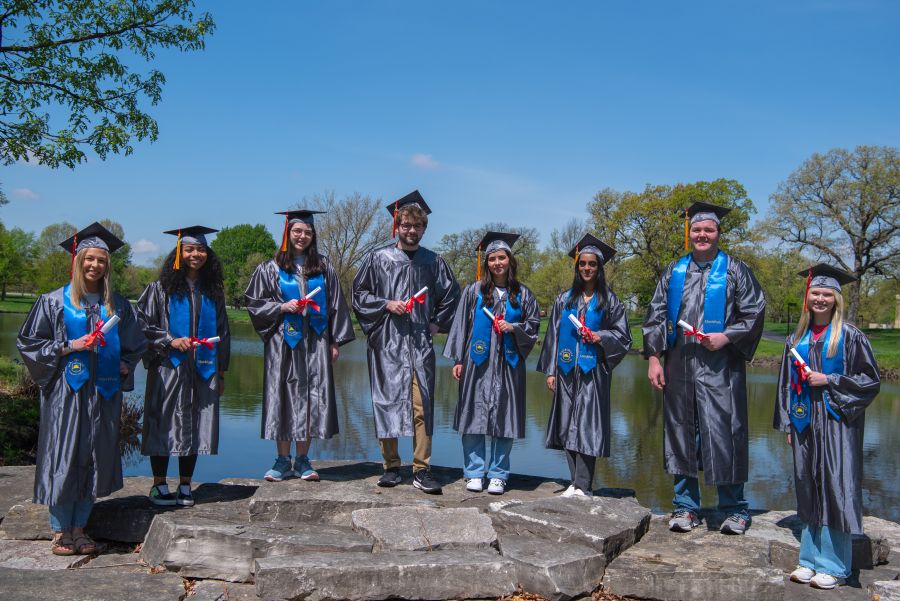 Graduates standing in front of lake huntoon