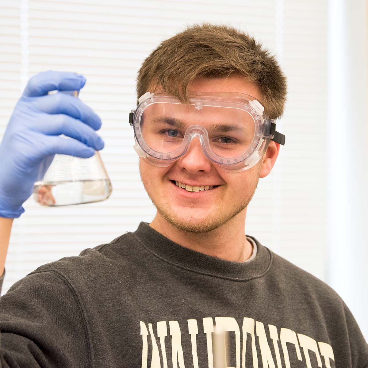 male student holding beaker