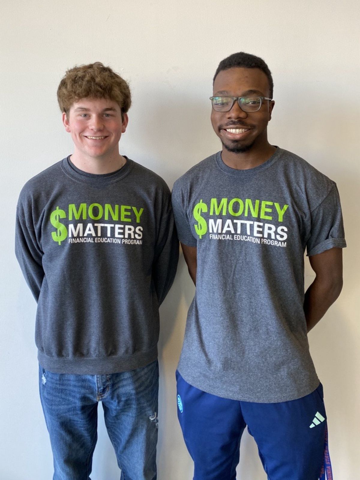 Two students wearing Money Matters t-shirts