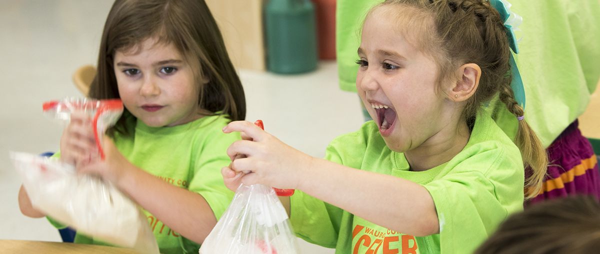 Girls in classroom holding plastic bags L
