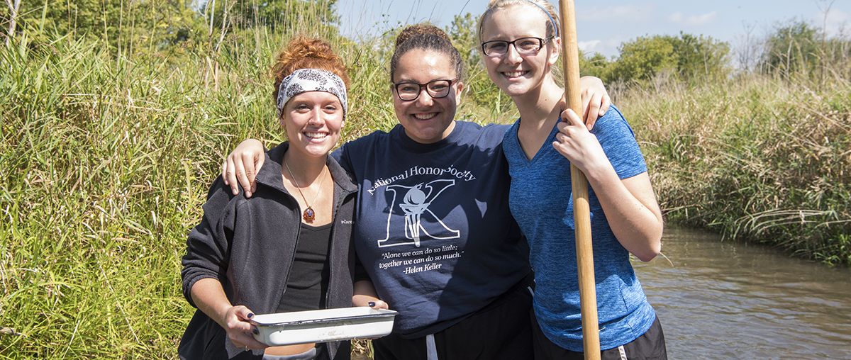 Students Biology standing in pond in summer L