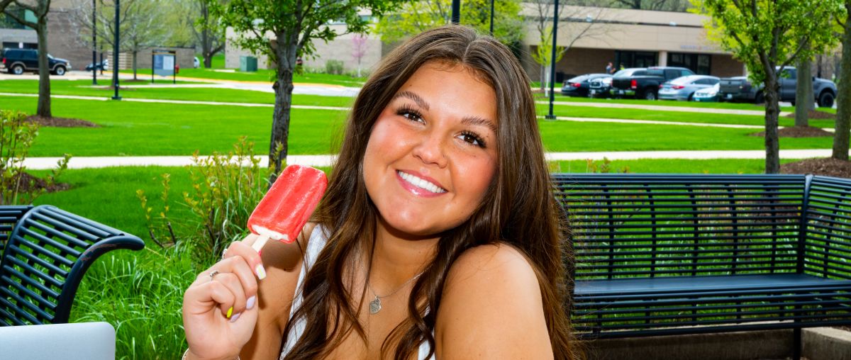 Summer Chill Girl sitting at table outside eating popsicle