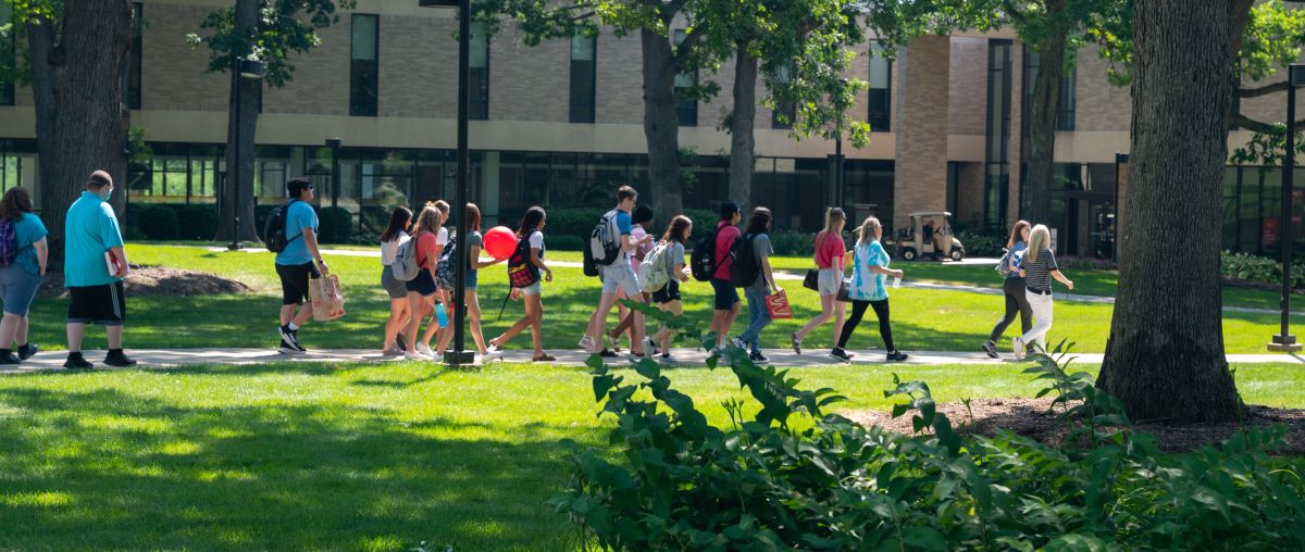 Students walking paths on campus in summer