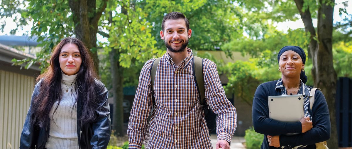 Three students walking outside in fall 2023