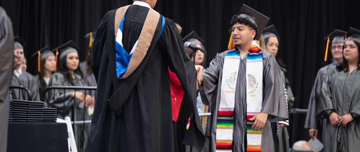 2024 graduate receiving diploma at commencement ceremony