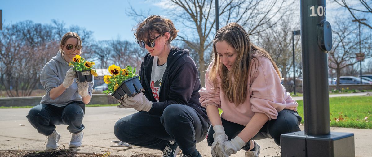 Students planting flowers on Day of Service 2024