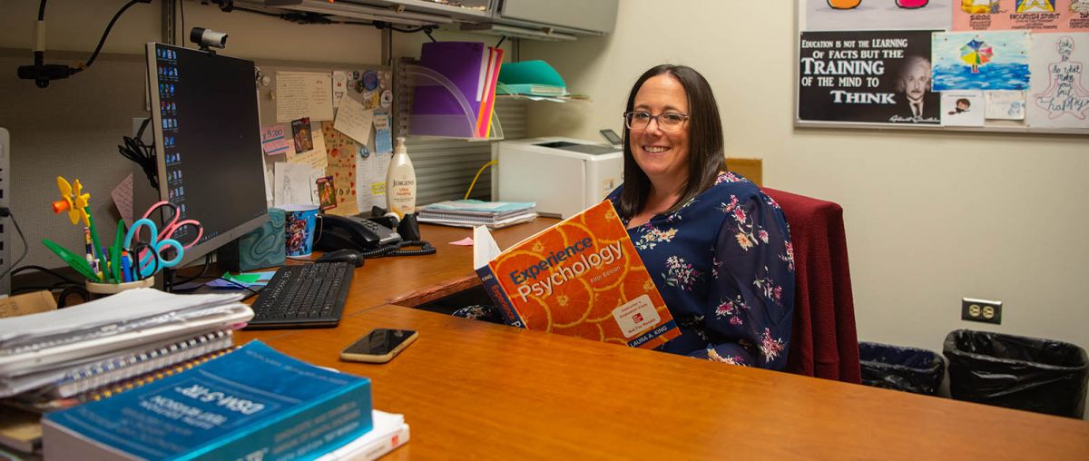 Laura Meredith sitting at desk hero image