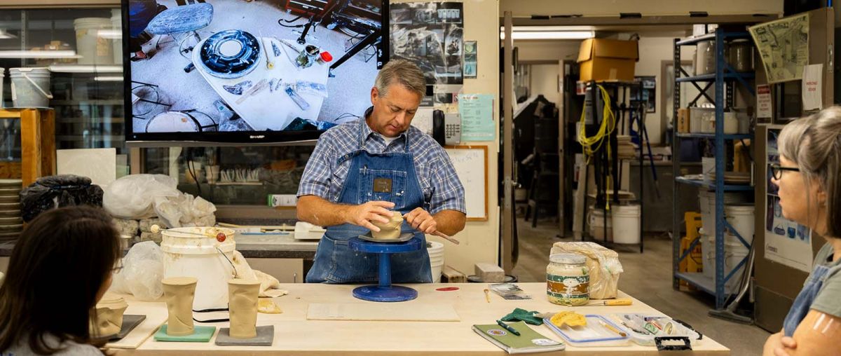 Photo of Doug Jeppesen demonstrating ceramics technique