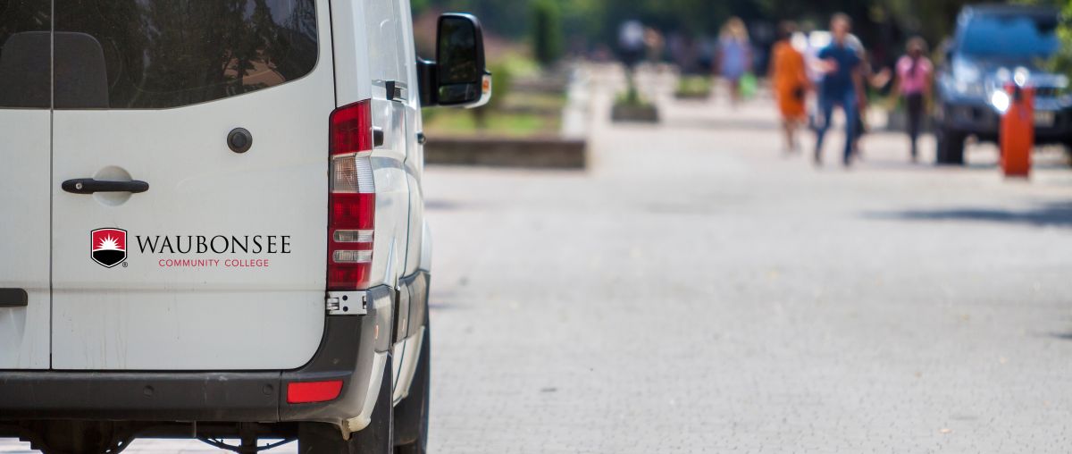 Waubonsee-branded shuttle van driving on the road