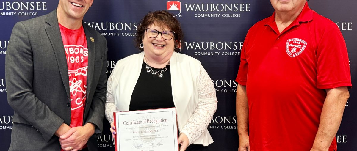 Waubonsee President Dr. Brian Knetl and Board of Trustee Patrick Kelsey present the 2026 Dr. Christine J. Sobek Outstanding Administrator Award to Dr. Stacey Randall, Executive Director of Institutional Effectiveness, Innovation, and Planning, at the August board of trustees meeting. 