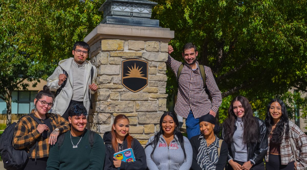 Group of students in front of pillar outside in fall