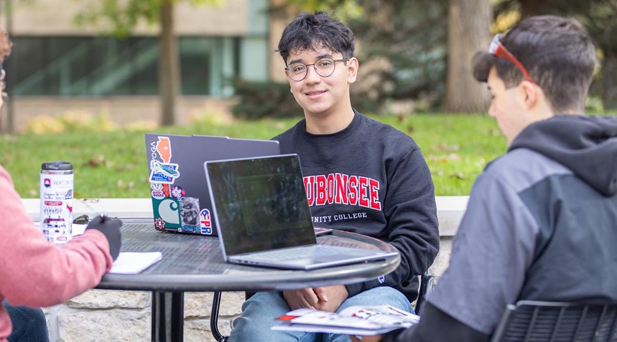 Students sitting at a table and talking outside at Sugar Grove Campus