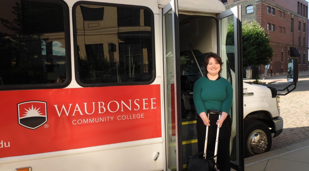 Krystal Donnelley posing in front of Waubonsee shuttle bus