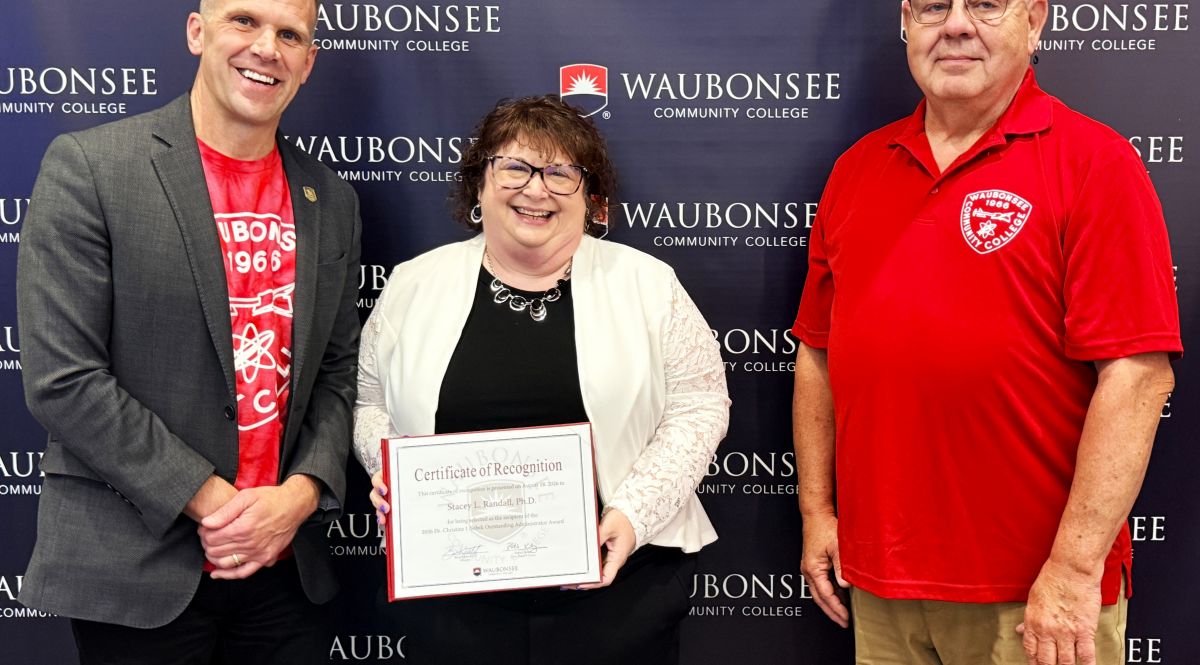 Waubonsee President Dr. Brian Knetl and Board of Trustee Patrick Kelsey present the 2026 Dr. Christine J. Sobek Outstanding Administrator Award to Dr. Stacey Randall, Executive Director of Institutional Effectiveness, Innovation, and Planning, at the August board of trustees meeting. 