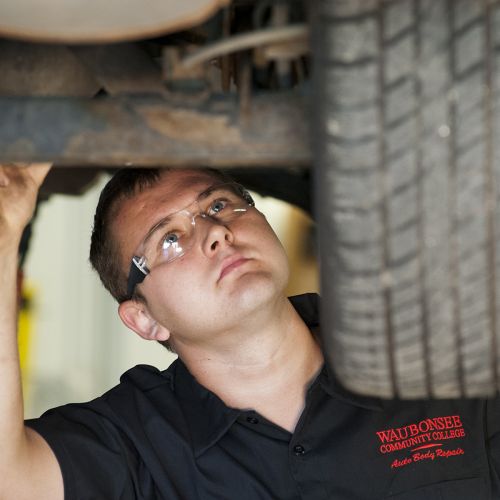 Auto Tech Student inspecting Tire Aligment