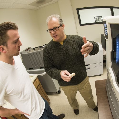 Faculty and student working with 3D printer