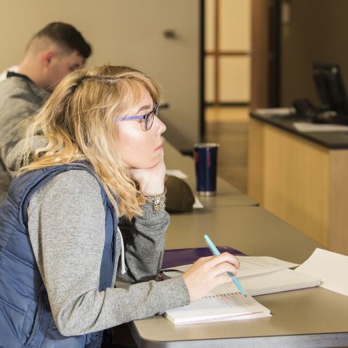 Student sits and listens in a Mass Communication classroom.