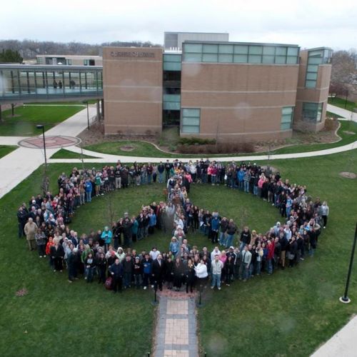 Photo of peace symbol with staff and faculty