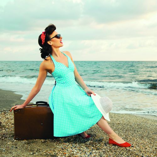 Girl from 50's on beach in blue dress red shoes s