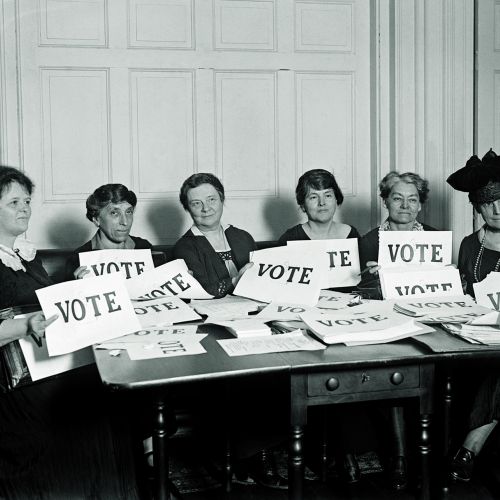 woman's right activists sitting with signs