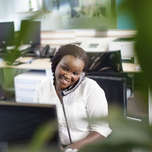 woman talking on a phone at a computer