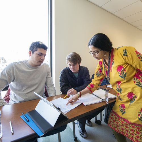 Teacher helping students with classwork