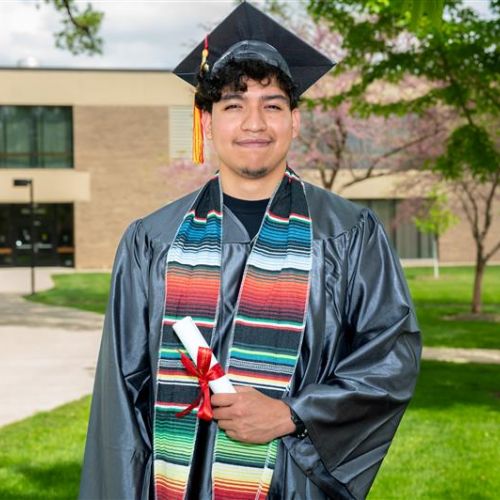 Jorge Lagunas Delgado, of Aurora Waubonsee graduate posing in cap and gown 
