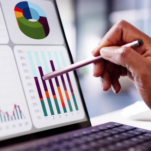 close up of someone working on a computer monitor/screen with graphs/charts