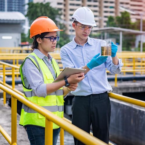 Wastewater workers examining water sample