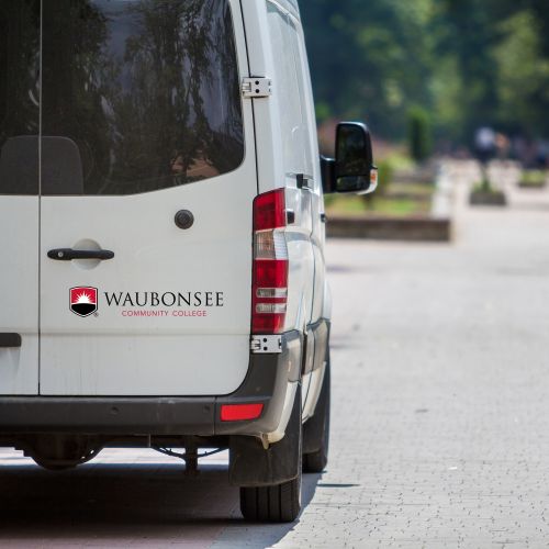 Waubonsee-branded shuttle van driving on the road