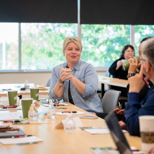 People around a conference table one person in focus
