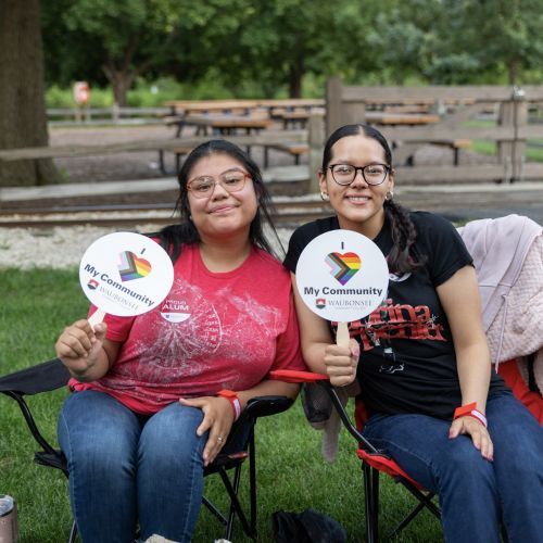 Alumni Night 2026 two alumni posing with hand fans