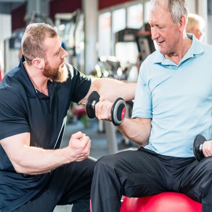 Photo of personal trainer working with older man