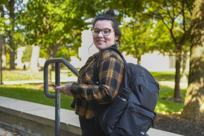 photo of woman with backpack on campus