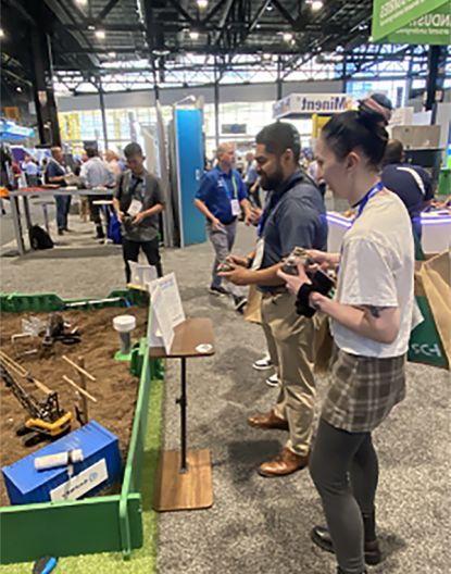 People interacting with a display at WEFTEC Conference