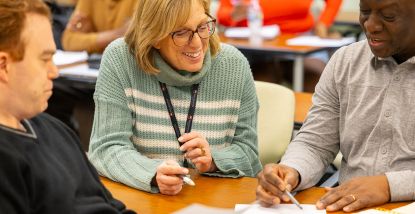 Faculty Michelle Hawley smiling looking at paperwork 
