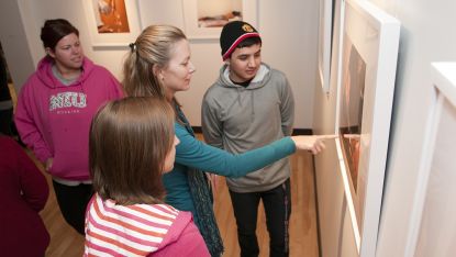 Art faculty Heather Weber shows students artwork in the Arrowhead Room. 