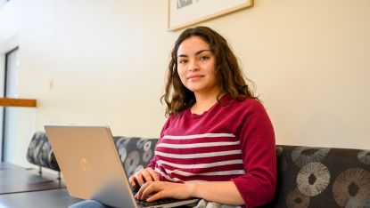 Female student working on a laptop by herself