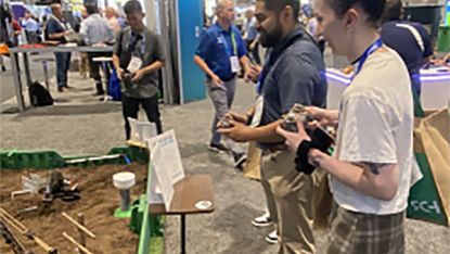People interacting with a display at WEFTEC Conference