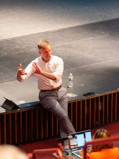 Dr. Knetl speaking on stage in front of audience