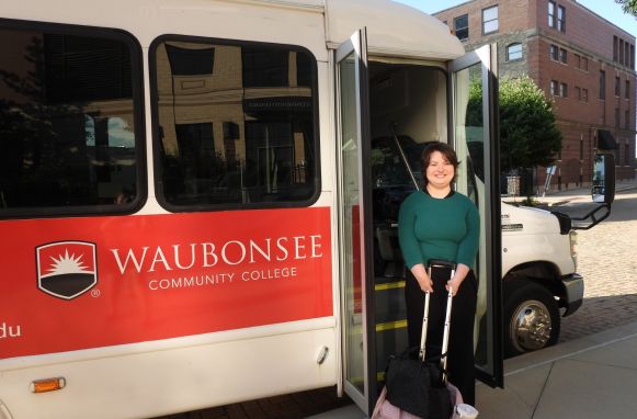 Krystal Donnelley posing in front of Waubonsee shuttle bus