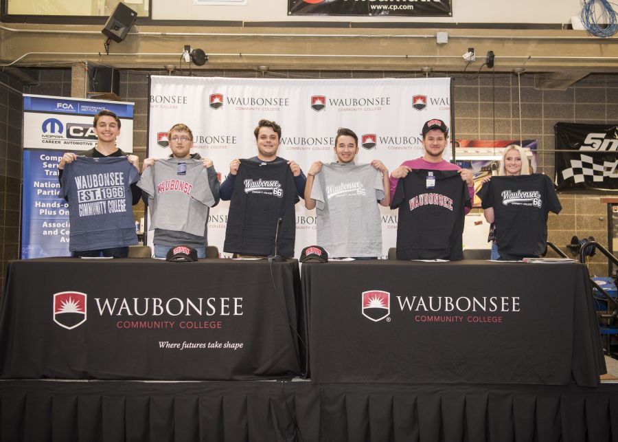Photo of students signing commitments to Waubounsee Auto Tech Program