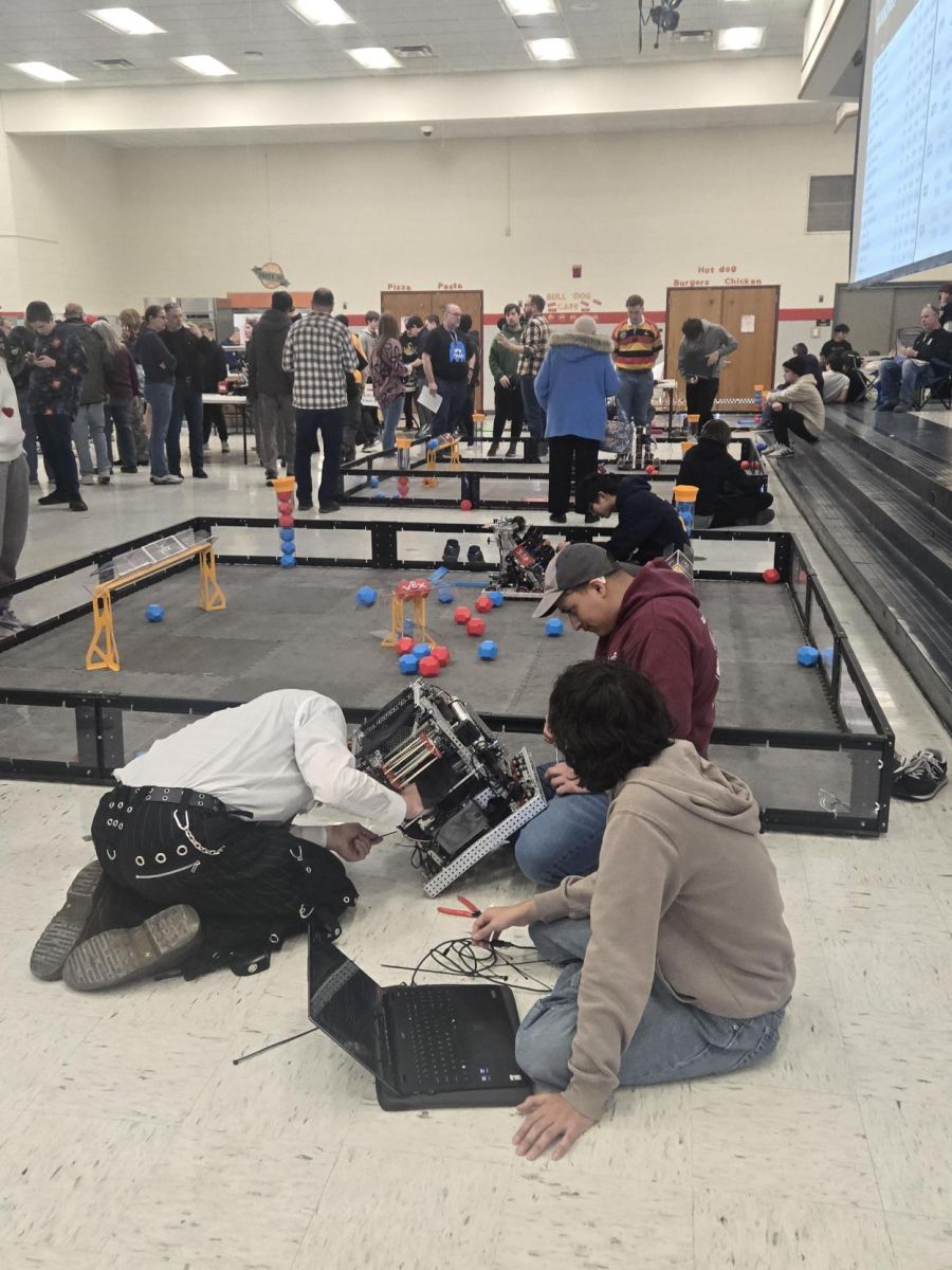 people walking around robot tournament and working on tournament