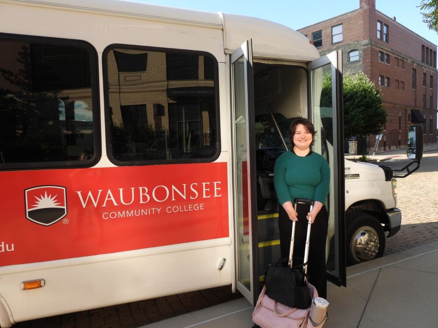 Krystal Donnelley posing in front of Waubonsee shuttle bus