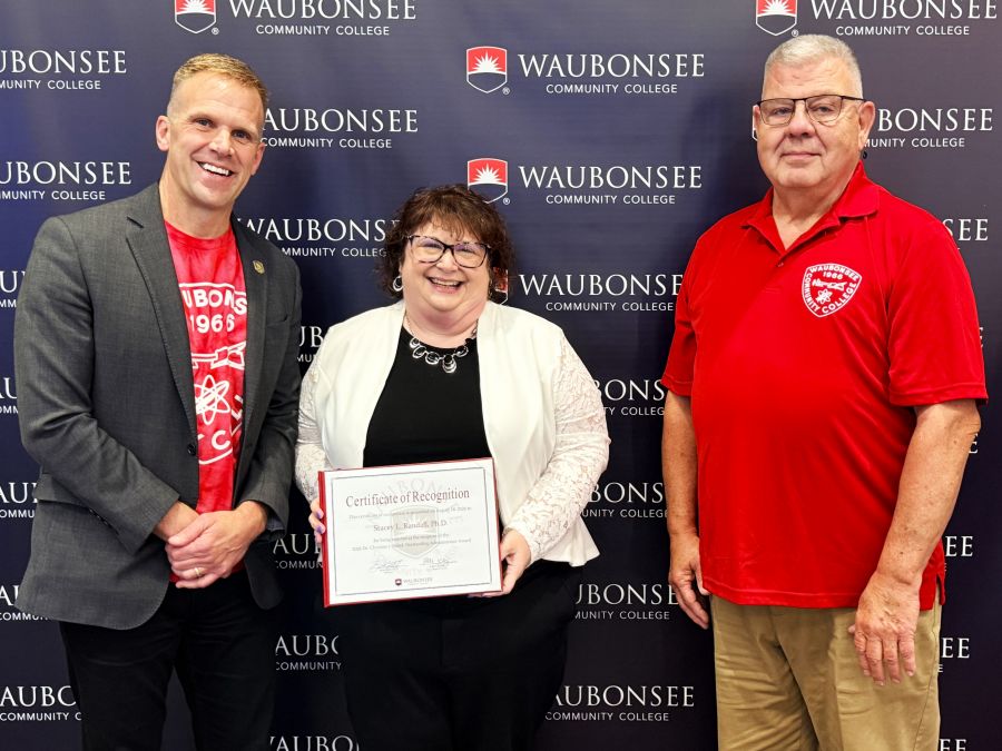 Waubonsee President Dr. Brian Knetl and Board of Trustee Patrick Kelsey present the 2026 Dr. Christine J. Sobek Outstanding Administrator Award to Dr. Stacey Randall, Executive Director of Institutional Effectiveness, Innovation, and Planning, at the August board of trustees meeting. 